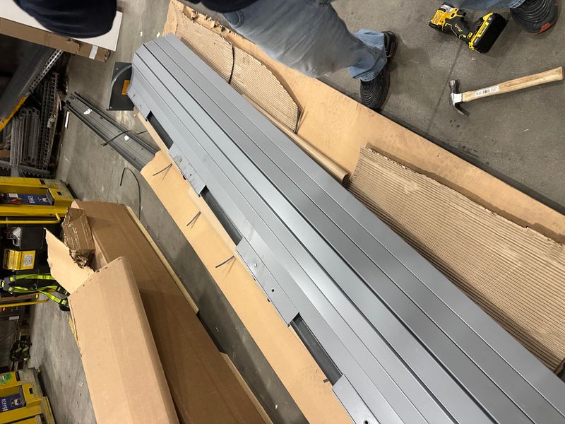 Garage door track pieces and hardware laid out for commercial installation in Massachusetts
